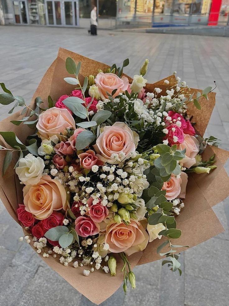 Mixed peach, pink and white roses with eucalyptus in kraft paper